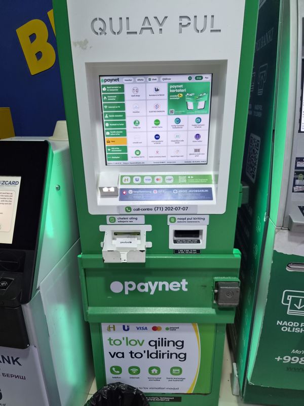 Терминал Paynet «Qulay pul» в Экобазаре в ряду банкоматов: оплата и пополнение («to'lov qiling va to'ldiring»), выдача чека