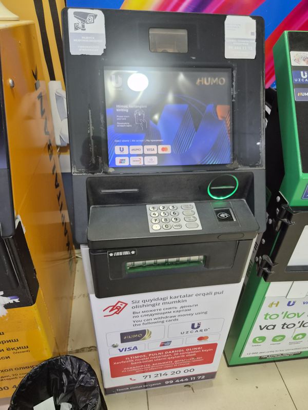Банкомат в Экобазаре: снятие наличных по картам Humo, Uzcard, Visa, Mastercard, UnionPay; на корпусе — наклейка техподдержки Poytaxt Bank