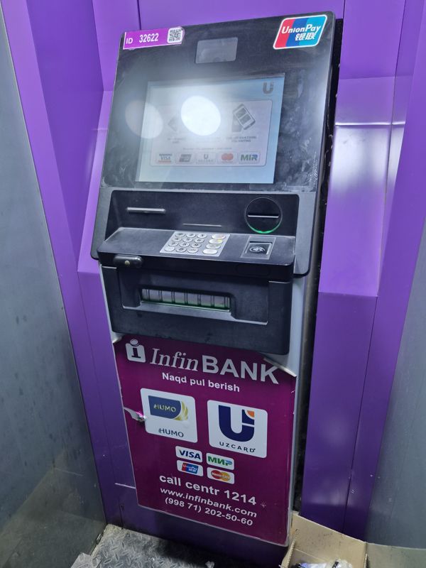 Банкомат InfinBANK в нише с фиолетовой отделкой: экран приветствия, клавиатура, бесконтактный считыватель, лоток выдачи наличных