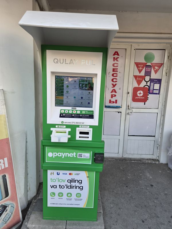 Уличный терминал Paynet «Qulay pul» под козырьком у входа в магазин аксессуаров: оплата и пополнение («to'lov qiling va to'ldiring»), карты Humo, Uzcard, Visa, Mastercard, call-центр (71) 202-07-07