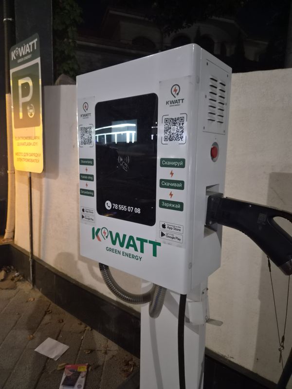 Зарядная станция электромобилей KWATT Green Energy на стене у парковочного знака «Место для зарядки электромобилей»; два QR-кода, телефон 78 555 07 08. Не банкомат.