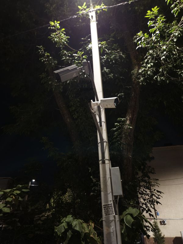 Ночью: светлый столб с двумя цилиндрическими камерами (одна Hikvision) и распределительным шкафом