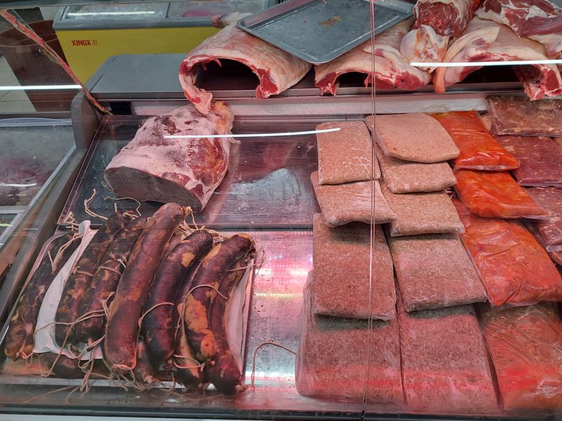 Витрина: вяленые колбасы на шпагате, фарш и маринованное мясо в вакуумных пакетах