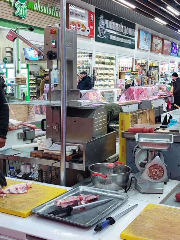Рабочее место мясника: пила для костей, мясорубка, разделочные доски; напротив мясной ряд