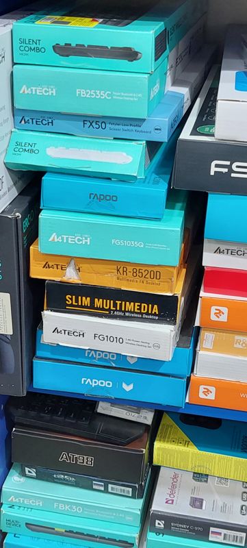 Стопка коробок клавиатур и комплектов A4Tech, Rapoo, Defender, Logitech