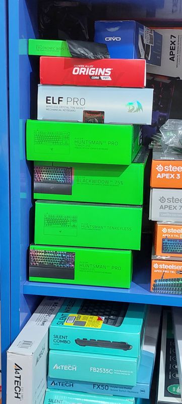 Полка с игровыми клавиатурами в коробках: Razer, HyperX, Redragon, SteelSeries; ниже A4Tech