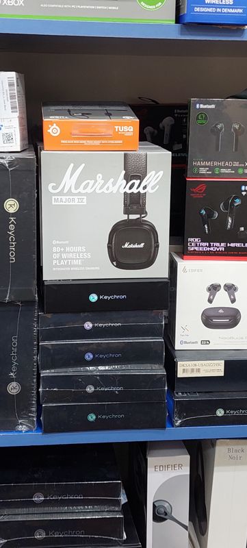 Полка с наушниками в коробках: Marshall Major IV, ROG Cetra, Razer Hammerhead, Edifier NeoBuds, SteelSeries TUSQ; клавиатуры Keychron
