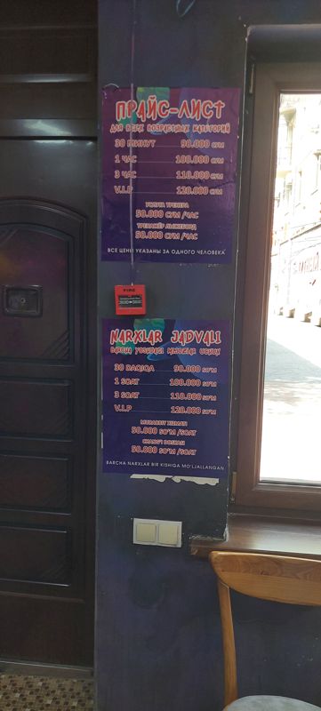 Прайс-лист и таблица цен (узб.) батутного центра на стене у окна