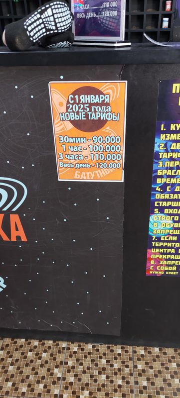 Оранжевая наклейка «С 1 января 2025 года новые тарифы» на стойке и правила посещения батутного центра