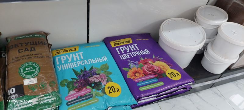 Нижняя полка крупнее: мешок «Цветущий сад», грунт универсальный и цветочный Агробалт Доброгряд по 20 л, справа стопка белых пластиковых вёдер с крышками