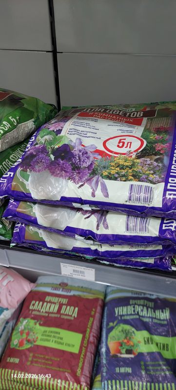 Стопка пакетов «Азбука Роста для цветов и комнатных растений» 5 л на полке, слева зелёные пакеты для фикусов; ниже Тайна Озера «Почвогрунт Сладкий плод» и «Универсальный Био Актив» по 10 л