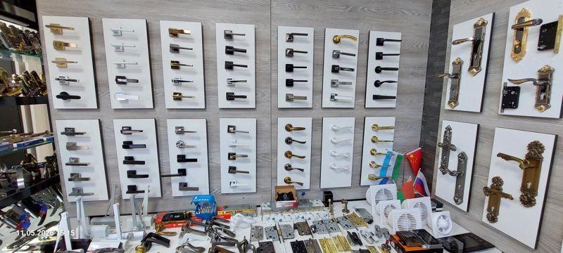 Витрина дверных ручек на розетках на белых панелях, ручки на накладках, внизу петли, врезные замки, доводчики и вытяжные вентиляторы