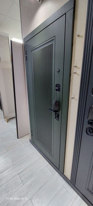 Образец входной двери тёмно-зелёного цвета с ребристой панелью и электронным замком; слева межкомнатные двери