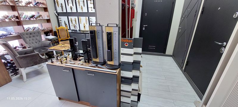Зал: витрина с врезными замками и умными замками Smart Lock, стенд Döllken с образцами профилей, стальные входные двери, слева полки с замками и дверной фурнитурой