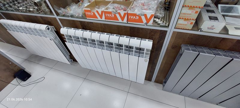 Радиаторы отопления белые секционные и серый, на витрине арматура IVAR, термостаты CLIMATIQ BT и Climate House