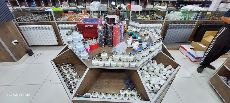 Островной прилавок: полипропиленовые фитинги с латунной резьбой, изолента, коробки, переходники; вокруг радиаторы и витрины с арматурой