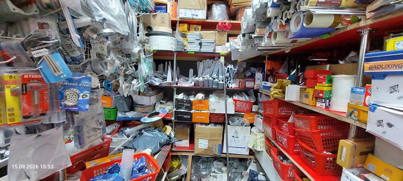Тесная кладовая-полка магазина: фурнитура и сантехника на крючках, красные корзины с мелочёвкой, плёнка самоклеящаяся в рулонах, шнуры, коробки Tarazi и Baolixing