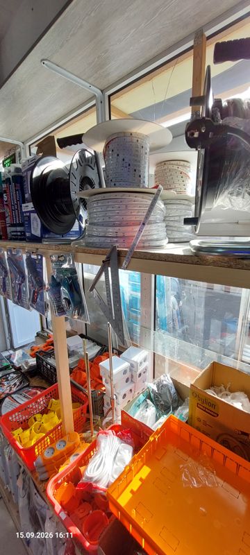 Верхняя полка: катушки с LED-лентой, катушки удлинителей, монтажная пена; ниже клеевые пистолеты, угольник; в корзинах подрозетники, распределительные коробки, розетки-удлинители