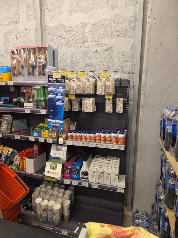 Торцевой стеллаж: свечи, БАДы NOW Foods, автохимия, зарядки, шоколад Merci, рядом кассовая зона