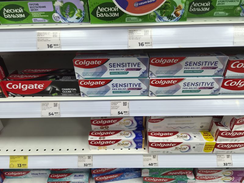 Полки с зубными пастами «Лесной бальзам» и Colgate, ценники белые, один жёлтый