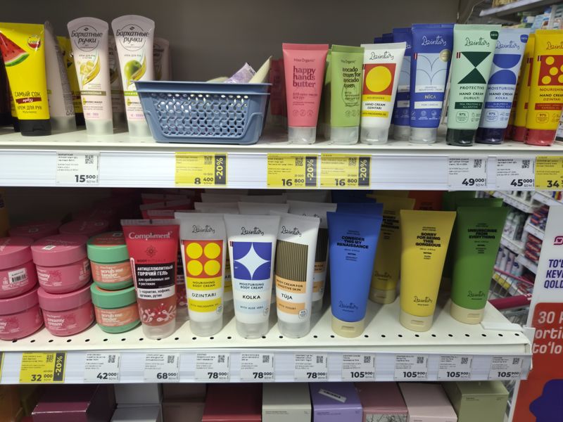 Две полки с кремами для рук и тела: Бархатные ручки, Miss Organic, Dzintars, ценники белые и жёлтые со скидкой