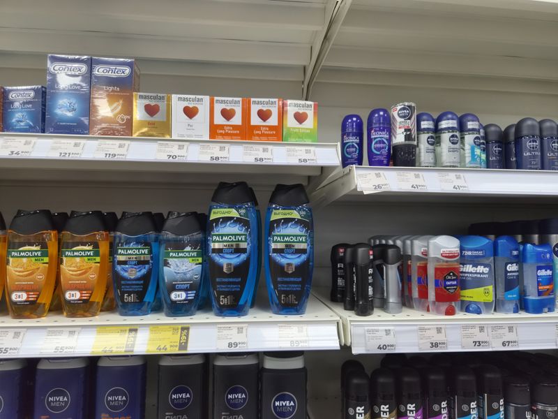 Витрина с презервативами, дезодорантами и гелями для душа Palmolive, ценники белые и жёлтые