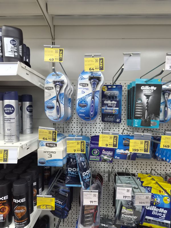 Стенд на крючках с бритвенными станками Schick, Gillette, Dorco, Zollider, жёлтые ценники со скидкой 20-83%