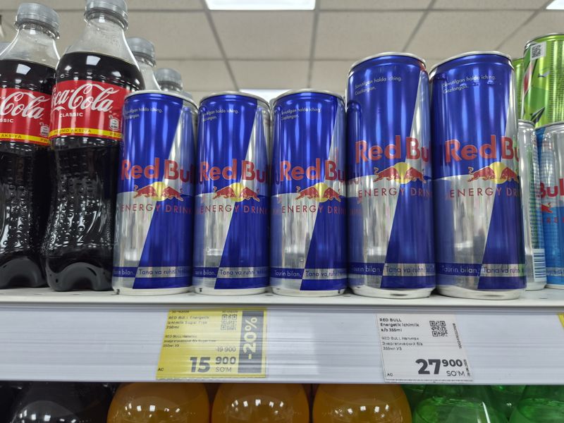 Полка с энергетиками Red Bull в банках, жёлтый ценник со скидкой и белый