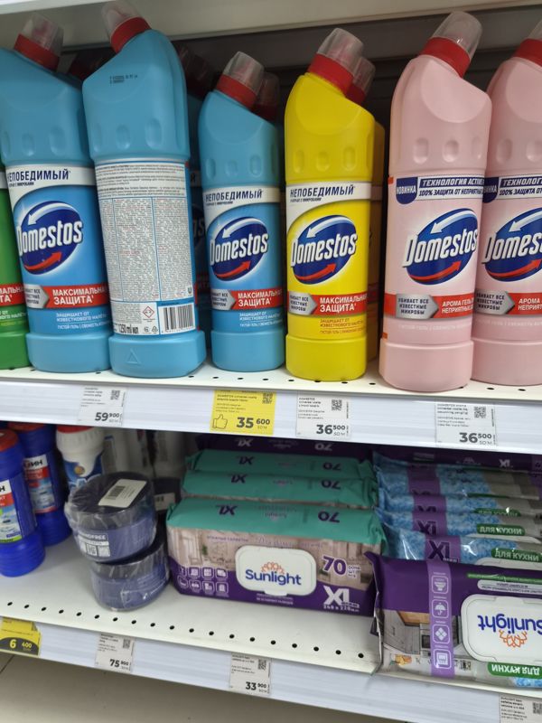 Полка со средствами Domestos и влажными салфетками Sunlight: белые ценники и один жёлтый