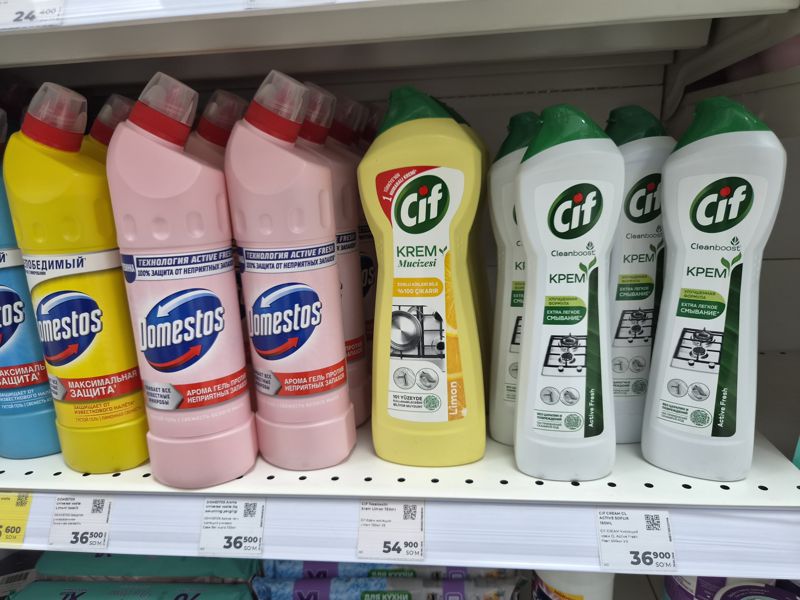 Полка с чистящими гелями Domestos и кремами Cif, белые ценники