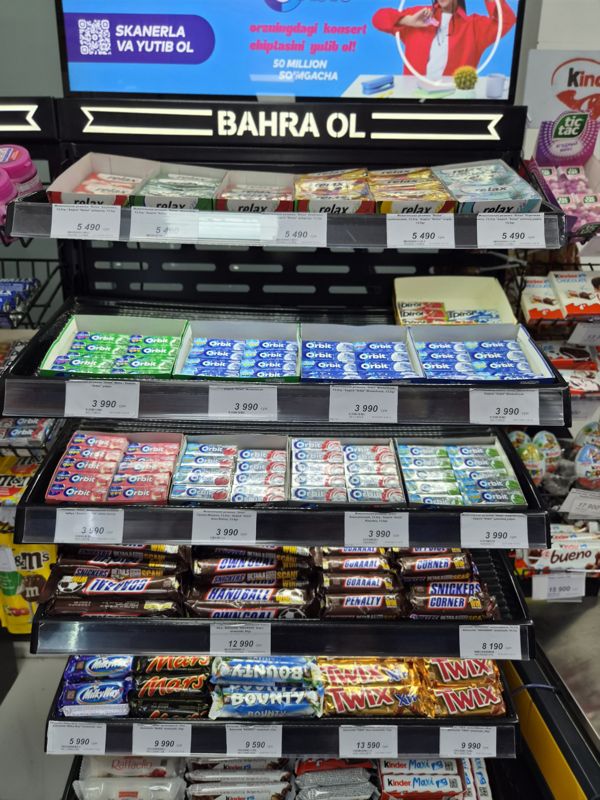 Стеллаж со жевательной резинкой Relax и Orbit и шоколадными батончиками Snickers, Milky Way, Mars, Bounty, Twix в Олме