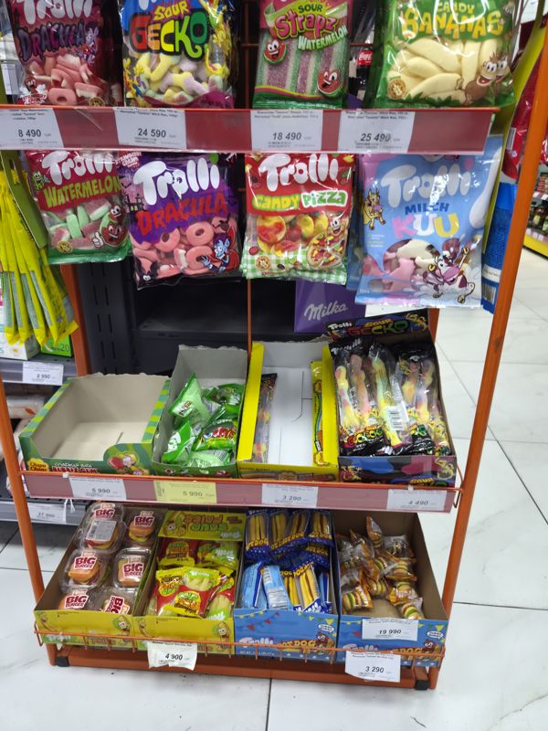 Нижняя часть стойки Trolli: пакеты Watermelon, Dracula, Candy Pizza, Milch Kuu на крючках, ниже коробки с мармеладом Chupa Chups и Trolli (Sour Gecko, Big Burger, Sour Fries, Hot Dog)