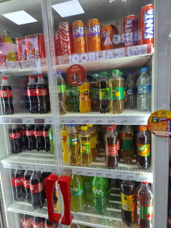Холодильник с напитками: банки Fanta, Coca-Cola и Sprite, ПЭТ-бутылки Coca-Cola, Fanta, Sprite, FuseTea, Cappy, Bonaqua; белые ценники на полках