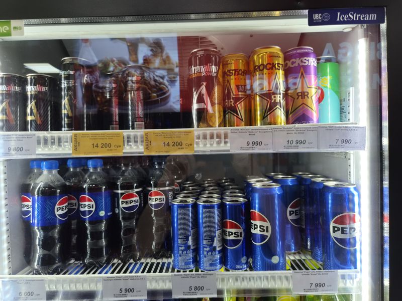 Холодильная витрина в супермаркете Олма: энергетики Adrenaline Rush и Rockstar, 7UP Mohito, Pepsi в бутылках и банках; ценники
