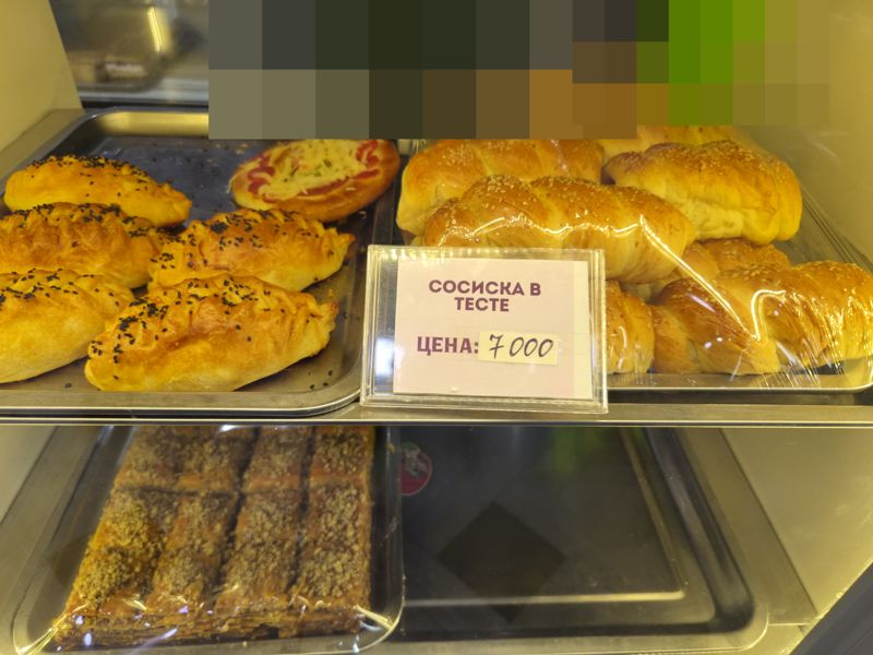 Витрина с выпечкой: сосиски в тесте, пирожки, пицца, пахлава