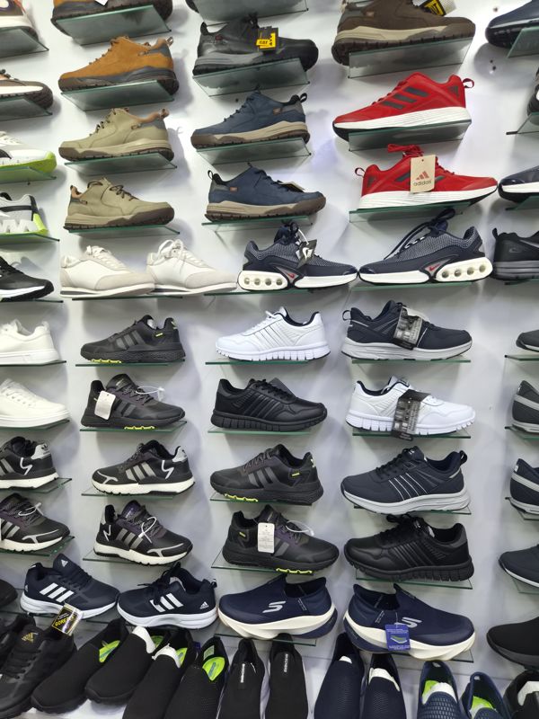 Стена мужских кроссовок и полуботинок: CAT, Adidas, Nike, Skechers