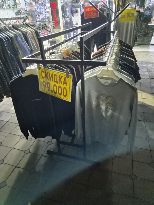 Стойки распродажи у входа: свитшоты со скидкой, футболки Nike, рубашки
