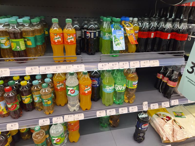 Газировка и холодный чай в бутылках 0,5–1 л на холодильной полке, белые полочные ценники