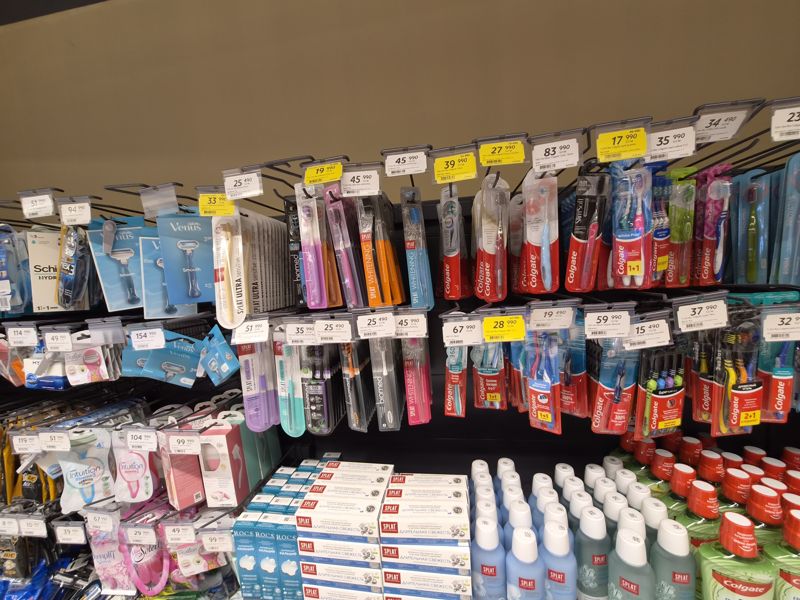 Станки и кассеты для бритья Gillette Venus, Schick, BIC и зубные щётки Splat, Biomed, Colgate на крючках; белые и жёлтые ценники Hafta super narxlari