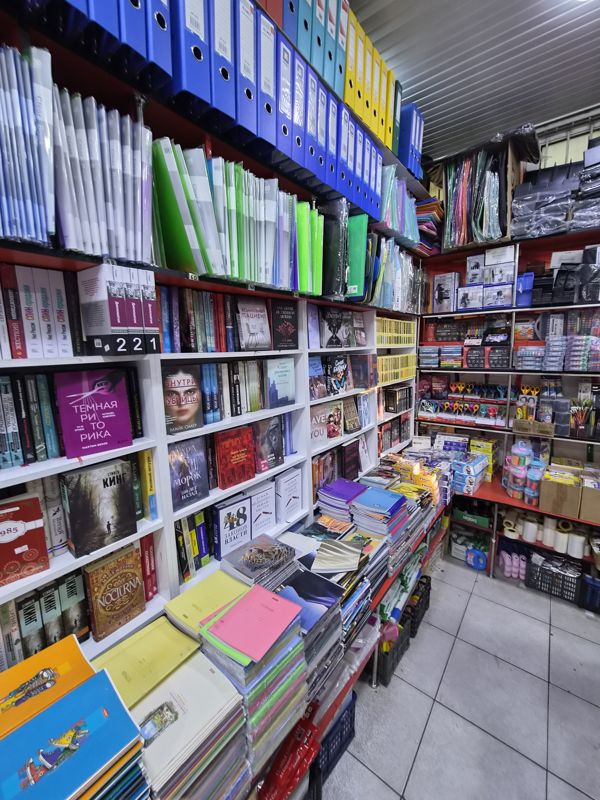 Азбука: угол с книгами на стеллажах, сверху папки-регистраторы и папки-файлы, справа канцтовары (маркеры, ножницы, органайзеры), внизу стопки тетрадей