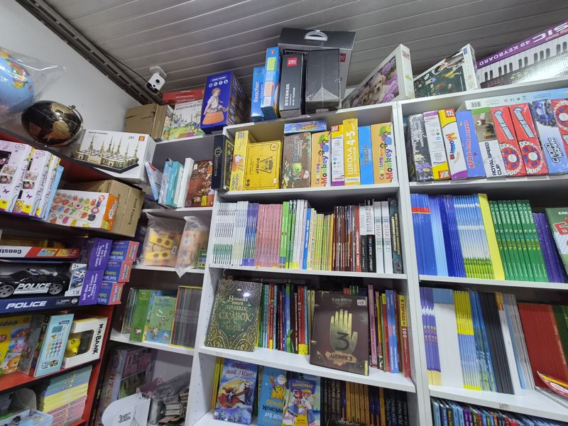 Азбука: стеллажи с детскими книгами, настольными играми и пазлами; сверху синтезатор