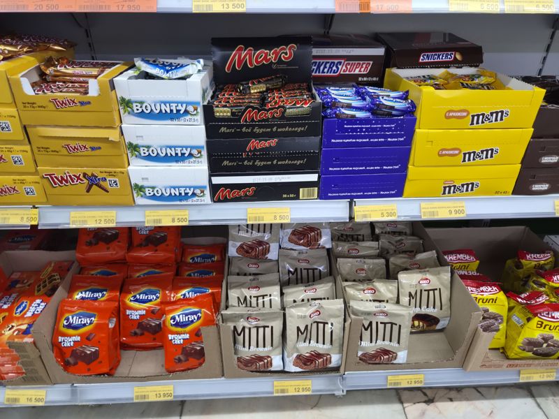 Havas: две полки с батончиками Twix, Bounty, Mars, Milky Way и драже M&M's в коробках, снизу кексы Miray, Isko Miti и Krember Bruni