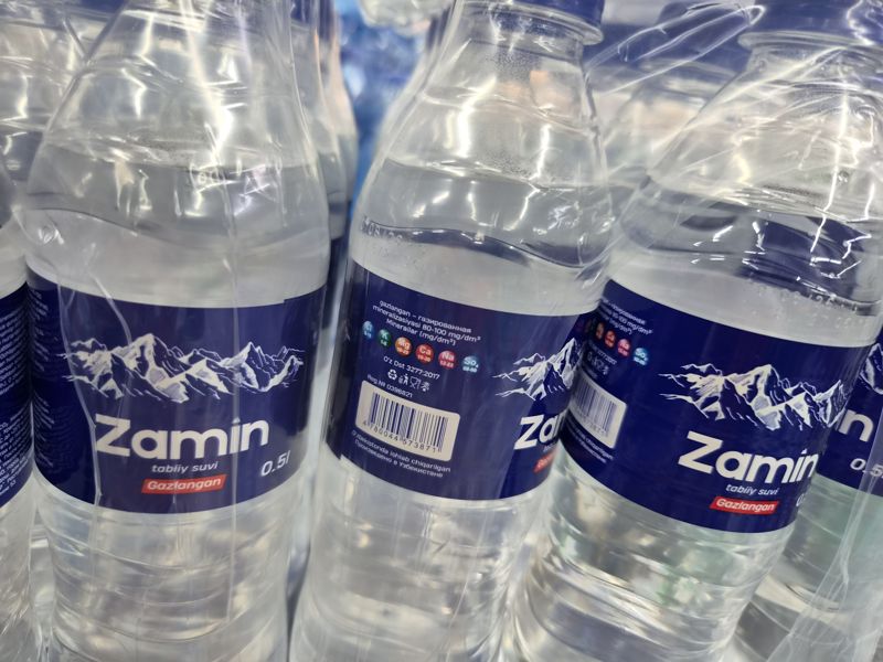Упаковки питьевой воды Zamin газированной 0,5 л в плёнке, на задней этикетке штрихкод