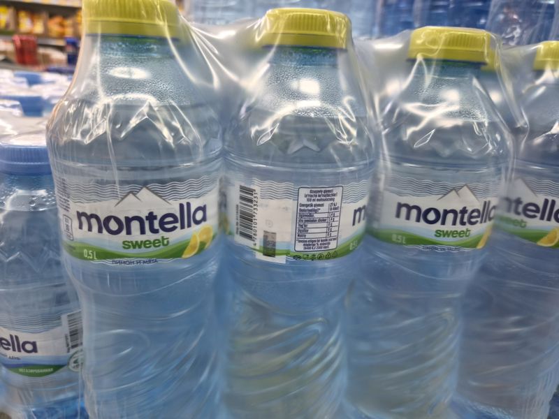 Упаковки Montella Sweet с лимоном и мятой 0,5 л в плёнке, на задней этикетке штрихкод; слева упаковка Montella негазированной
