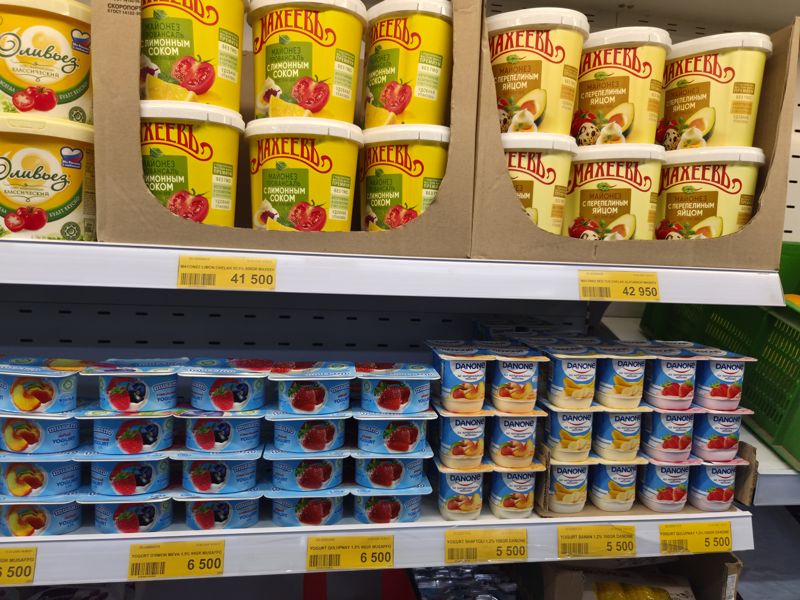 Витрина: майонез Махеевъ и Оливьез в вёдрах, ниже йогурты Musaffo и Danone с жёлтыми ценниками