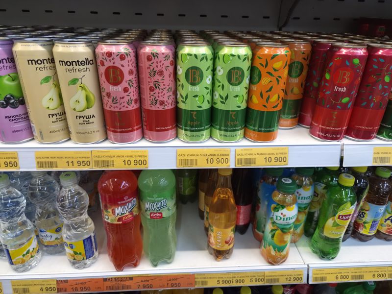 Две полки напитков: сверху банки Montella Refresh и B-Fresh, ниже бутылки Chernogolovka Мохито, Flavis, Dinay, Lipton; на ленте жёлтые и оранжевые ценники
