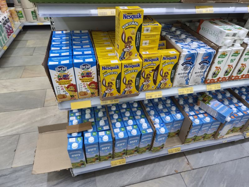 Полка с молоком и молочными коктейлями в картонных пакетах 1 л: Nesquik, Lactel, Kalleh, Pure Milky, Musaffo; жёлтые ценники на планках