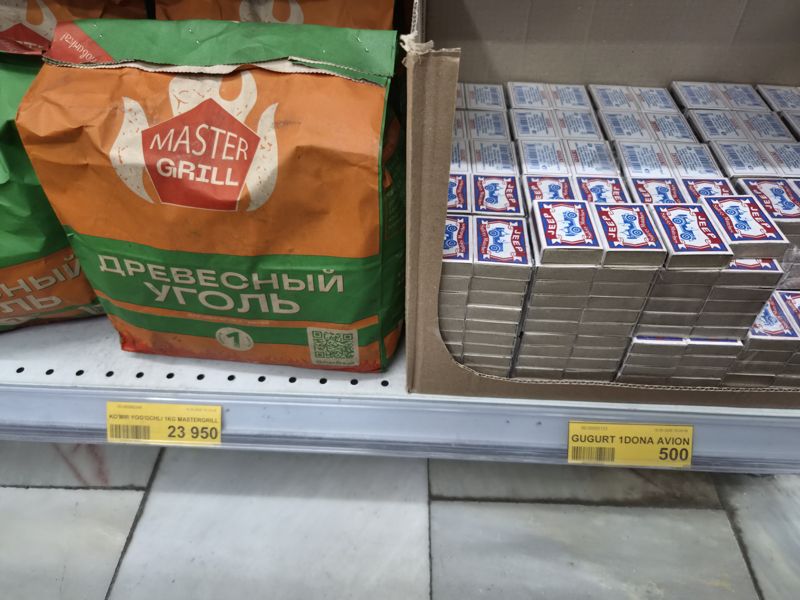 Полка Havas: древесный уголь Master Grill в бумажных пакетах и спички в коробках на полке рядом, два ценника