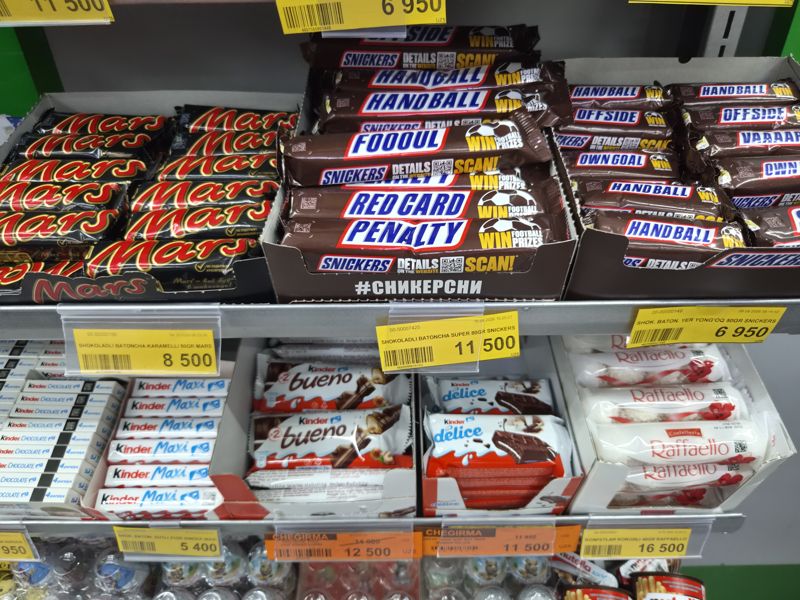 Стеллаж Havas с шоколадными батончиками Mars и Snickers, Kinder Maxi, Bueno, Delice, конфетами Raffaello; внизу Nutella и Kinder-яйца