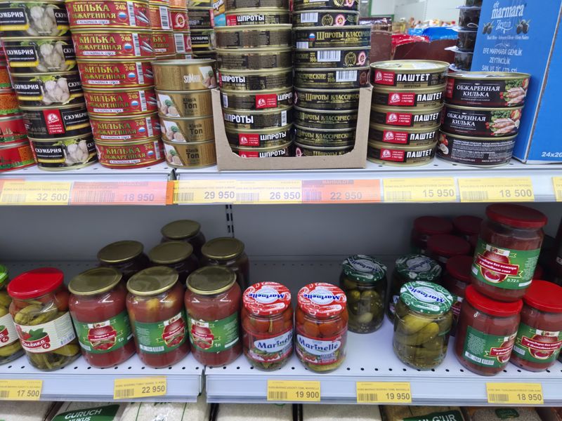 Havas: полка с рыбными консервами (За Родину, Вкусные консервы, Sumare) и нижняя полка с маринованными овощами (Kanz, Marinelle), жёлтые ценники